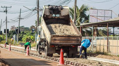 Chiang Mai Thai 23 December 2021 Construction workers are adjusting road surface with heavy machinery to achieve smooth surface and compact ground before pouring reinforced concrete give road strength