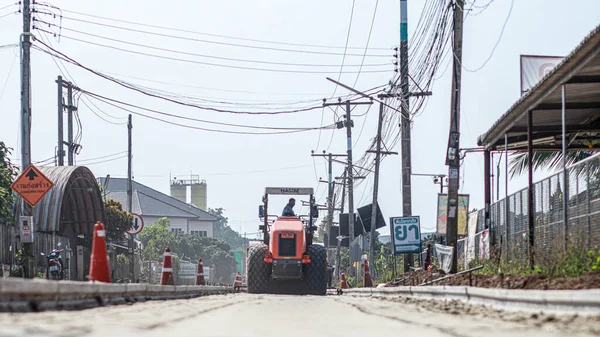 Chiang Mai Thai 23 December 2021 Construction workers are adjusting road surface with heavy machinery to achieve smooth surface and compact ground before pouring reinforced concrete give road strength