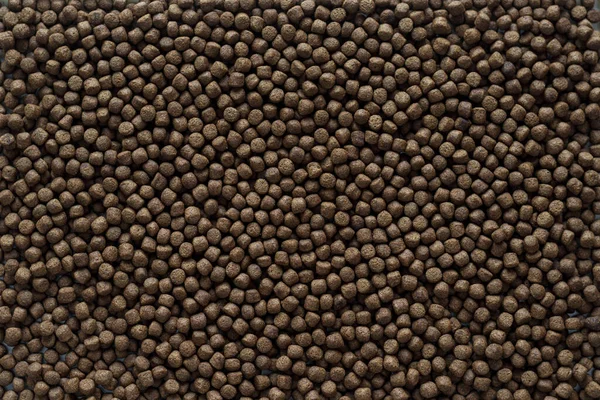 Animal feed mixed from finely ground protein powders of both plants and animals is pelleted to be used as pet food because pellets are convenient and accurate in feeding quantity.Copy Space background