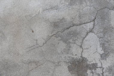 Beton yüzeyin arka planı beton duvardaki deseni ve çatlakları gösteriyor. Bir süre sonra beton duvar ısı ve titreşim nedeniyle çatlıyor..
