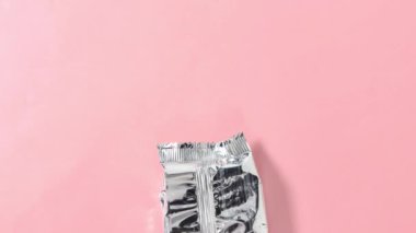 Hareket animasyonunu durdur. Pembe arka plandaki paketten kurabiye paketini açıyorum. Üst görünüm.