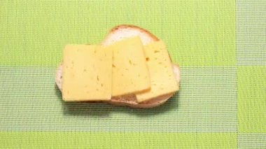 Hareket animasyonunu durdur. Yavaş yavaş ısıran bir peynirli sandviç. Bir şeyler atıştır. Üst görünüm.