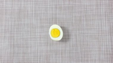 Hareket animasyonunu durdur. Haşlanmış yumurtanın yarısı elinde. Bir şeyler atıştır. Üst görünüm.