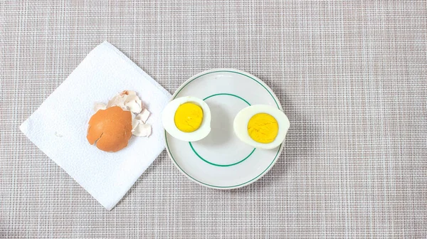 Две Половинки Вареного Яйца Тарелке Рядом Которой Находится Яичная Скорлупа — стоковое фото