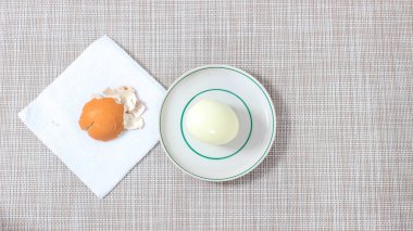 Yanında yumurta kabuğu olan kaynamış bir yumurta tabağı. Üst görünüm.