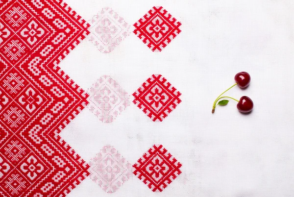 赤の明るい白いウクライナ テーブル クロスに甘い熟したチェリー ストック画像