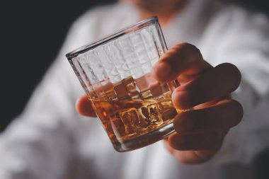 Adam bir şeyler içmeye. Bir adam barda viski içme closeup kırpılmış.