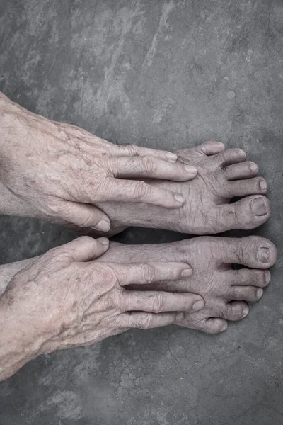 Asyalı yaşlı adam elleri ve ayakları. Ortak sağlık ve bakım kavramı ve yaşlanan deri kavramı. Somut arka planda izole edilmiş.