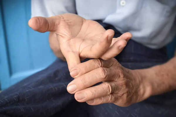 Strengthening exercise for finger health of Asian elder male patient with muscle spasm.