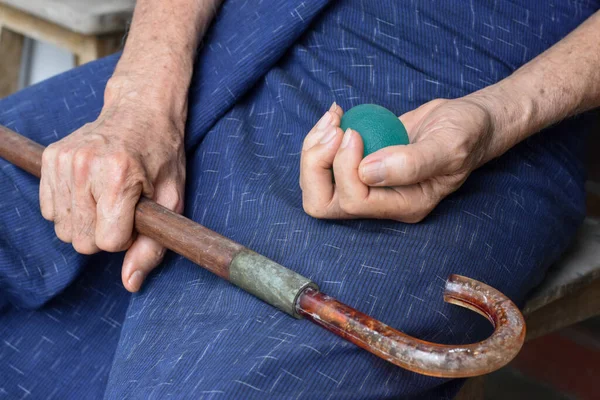 Southeast asian, Chinese old man gripping hand exercise elastic ball.