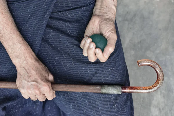 Southeast asian, Chinese old man gripping hand exercise elastic ball.