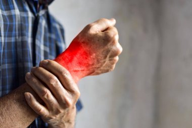 Asyalı ihtiyarın bileğinde iltihap var. Eklem ağrısı veya osteoartrit kavramı.