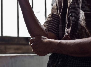 Güneydoğu Asyalı yaşlı bir adamın dirsek eklemindeki kısmi acı silueti. Dirsek ağrısı veya osteoartrit kavramı.