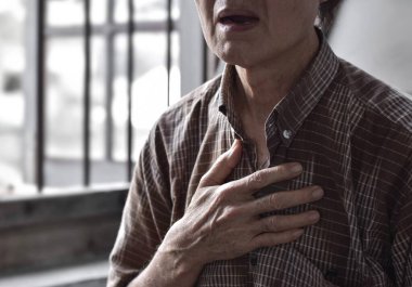 Asian elder man suffering from tightness of chest. It can be caused by asthma, bronchitis, bronchiolitis, pneumonia, myocardial infarction, ischemic heart disease, esophagitis, etc.