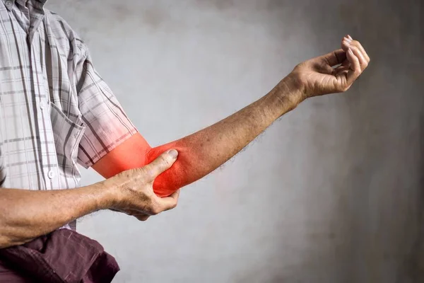 Pain in the elbow joint of Southeast Asian elder man. Concept of elbow pain or osteoarthritis.