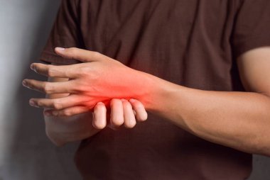 Elini kaşıyan Asyalı genç bir adam. Uyuz, mantar enfeksiyonu, egzama, sedef, kızarıklık, alerji gibi kaşındırıcı deri hastalıkları kavramı..