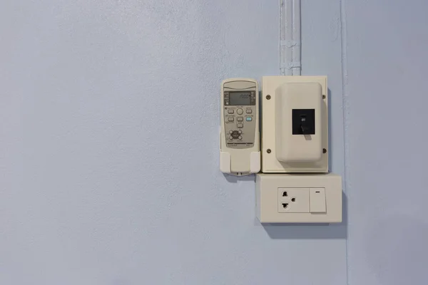 White bridge box with power control switch inside the house and remote air conditioner wiring on concrete wall. With electrical equipment objects