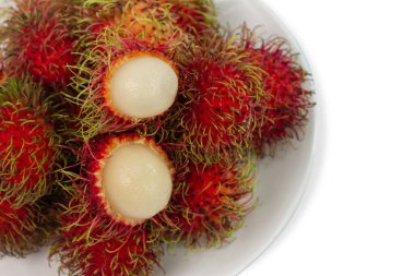 Taze kırmızı rambutan ve kopyalama alanı olan beyaz bir plakanın üst görüntüsü