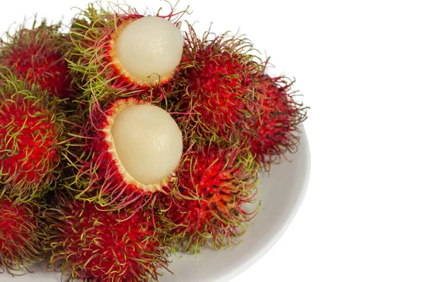 Heap of rambutan in a white dish with a white background