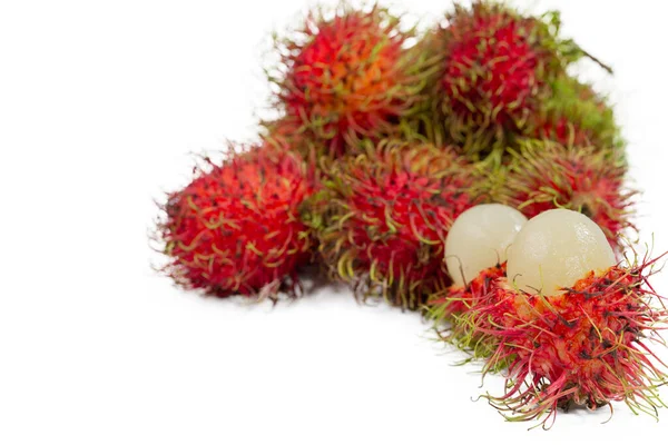 Rambutan is a red fruit with red and green feathers stacked together on a white background in the market.