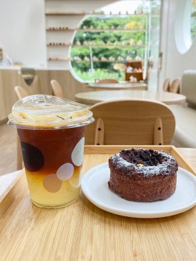 Kahverengi çikolatalı cheesecake. Kahverengi sütlü kahve kupası. Lokantada atıştırmalık masası.