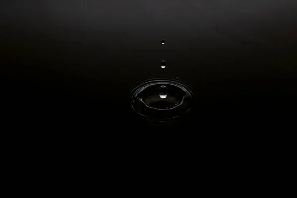 nature of the water droplets that drip onto the black surface