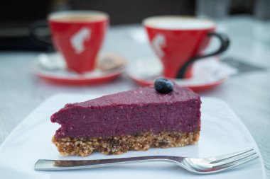 Kahve fincanlarıyla servis edilen bir dilim Slovenya yaban mersinli keki.