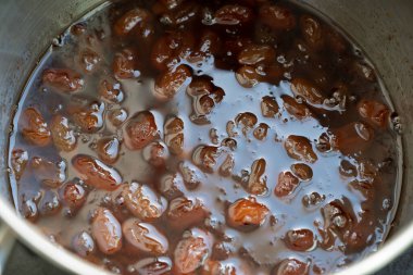 Ev yapımı reçel yapma sürecinin bir parçası olarak, şekerli bir tencerede kaynatılan üzümler