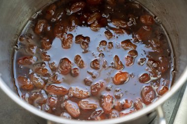 Ev yapımı reçel yapma sürecinin bir parçası olarak, şekerli bir tencerede kaynatılan üzümler