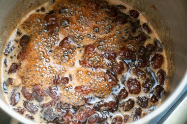 Ev yapımı reçel yapma sürecinin bir parçası olarak, şekerli bir tencerede kaynatılan üzümler