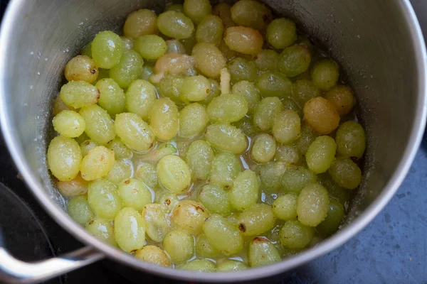 Fresh Green grapes, boiling in a pot with sugar, the first step in the process of making homemade jam