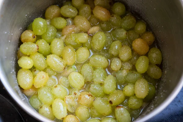 Fresh Green grapes, boiling in a pot with sugar, the first step in the process of making homemade jam