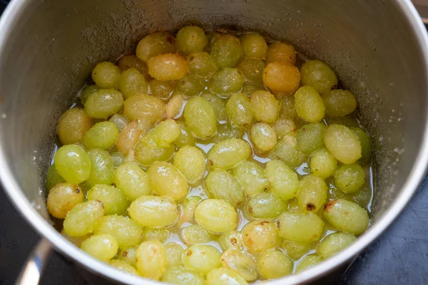 Fresh Green grapes, boiling in a pot with sugar, the first step in the process of making homemade jam