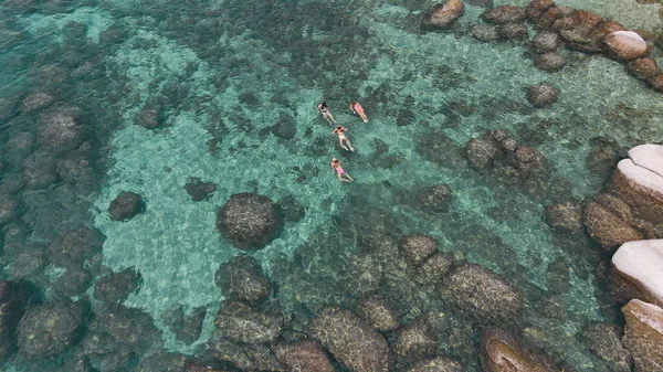 Crystal clear Lake Tahoe rocky shoreline. Ladies relaxing in the crystal clear water. High quality photo