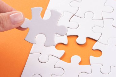 Turuncu yüzeyde bulmaca parçaları tutuyor. Beyaz yapboz oyun dokusu. Uyumlu, son kayıp parça yerleştiriliyor. İş ve takım çalışması problem çözme geçmişi. Metin eklemek için boşluk kopyala, kapat.