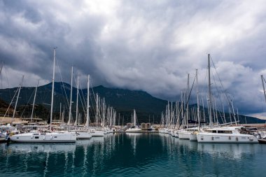 Güzel bulutlu gökyüzü ve deniz manzarası. Türkiye 'nin Mugla kentindeki Datca' da lüks yat marinası. Kasvetli hava su yüzeyine yansıyor. Deniz arkaplanı