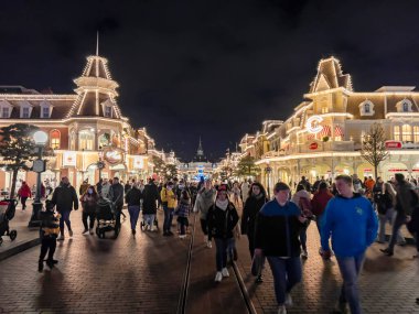 Paris, Fransa - 04 / 05 / 2022: Geceleri Disneyland 'in renkli meydanı. Etrafta dolaşan insanlar.
