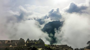 Stone Temple in Machu Picchu on foggy day early in the morning. High angle view. Natural and historical background with copy space. Machu Picchu is an Incan citadel set high in Andes Mountains in Peru