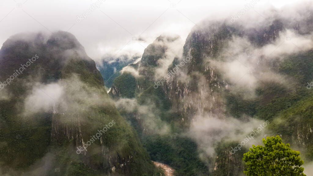 Beautiful high Andes Mountains view from Machu Picchu, in Peru, on foggy day early in the morning. High angle view. Natural and historical background with copy space.  