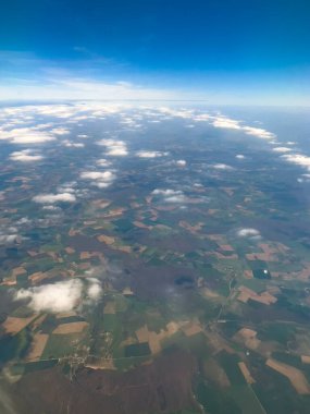 Mountain aerial view high up from plane. Airplane window and air travel concept: Looking out aircraft bull's eye. Beautiful scenery from the air through plane porthole. Travel background, copy space