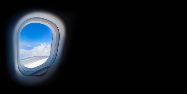 Bull\'s eye view on beautiful sky, black background. View from airplane window and air travel concept. Looking out aircraft bull\'s eye. Beautiful scenery from the air through plane porthole.