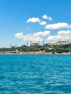 Vertical historical view on Istanbul city on a sunny day with Ottoman Topkapi museum, Hagia Spohia church and Blue Mosque in background. Beautiful travel destination postcard, poster banner