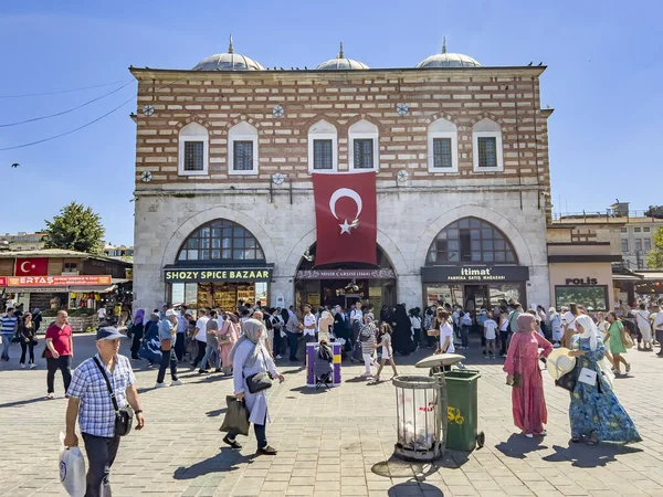 Istanbul, Turkey, 07.14.2022: Beautiful building entrance of the traditional old Egyptian Spice Market at Eminonu next to famous grand Bazaar. Muslim men and hijab scarf women tourists shopping at day