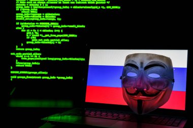 İntikam maskeli Rus isimsiz hackerlar. Arka planda Rus bayrağı ve programlama kodu