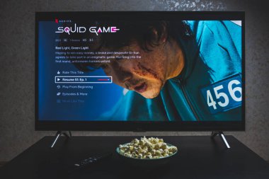 Televizyonda Squid 'in yarışmasını izliyorum. Squid Game, Netflix 'te yayınlanan bir Güney Kore drama dizisidir.