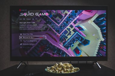 Televizyonda Squid 'in yarışmasını izliyorum. Squid Game, Netflix 'te yayınlanan bir Güney Kore drama dizisidir.