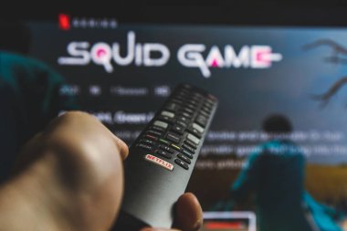 Televizyonda Squid 'in yarışmasını izliyorum. Squid Game, Netflix 'te yayınlanan bir Güney Kore drama dizisidir.