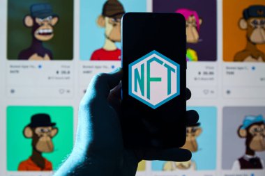 NTF logosu NTF 'nin arka planında akıllı telefondan. Finanse edilemeyen sembol, dijital bir defterde depolanan eşsiz ve değiştirilemez bir veri birimidir.