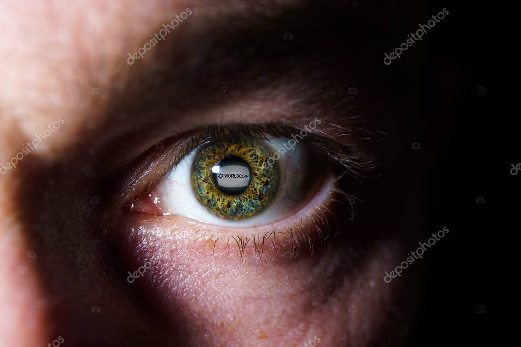 Worldcoin cryptocurrency reflection on eye. Worldcoin is a digital currency that launches by giving away a piece to every person in the world.