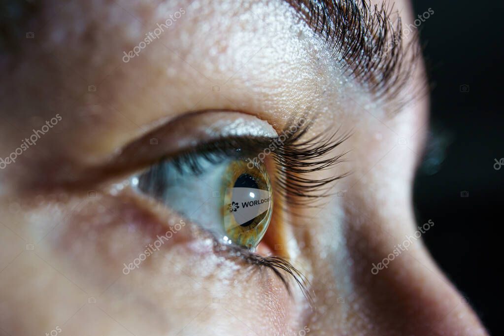 Worldcoin cryptocurrency reflection on eye. Worldcoin is a digital currency that launches by giving away a piece to every person in the world.